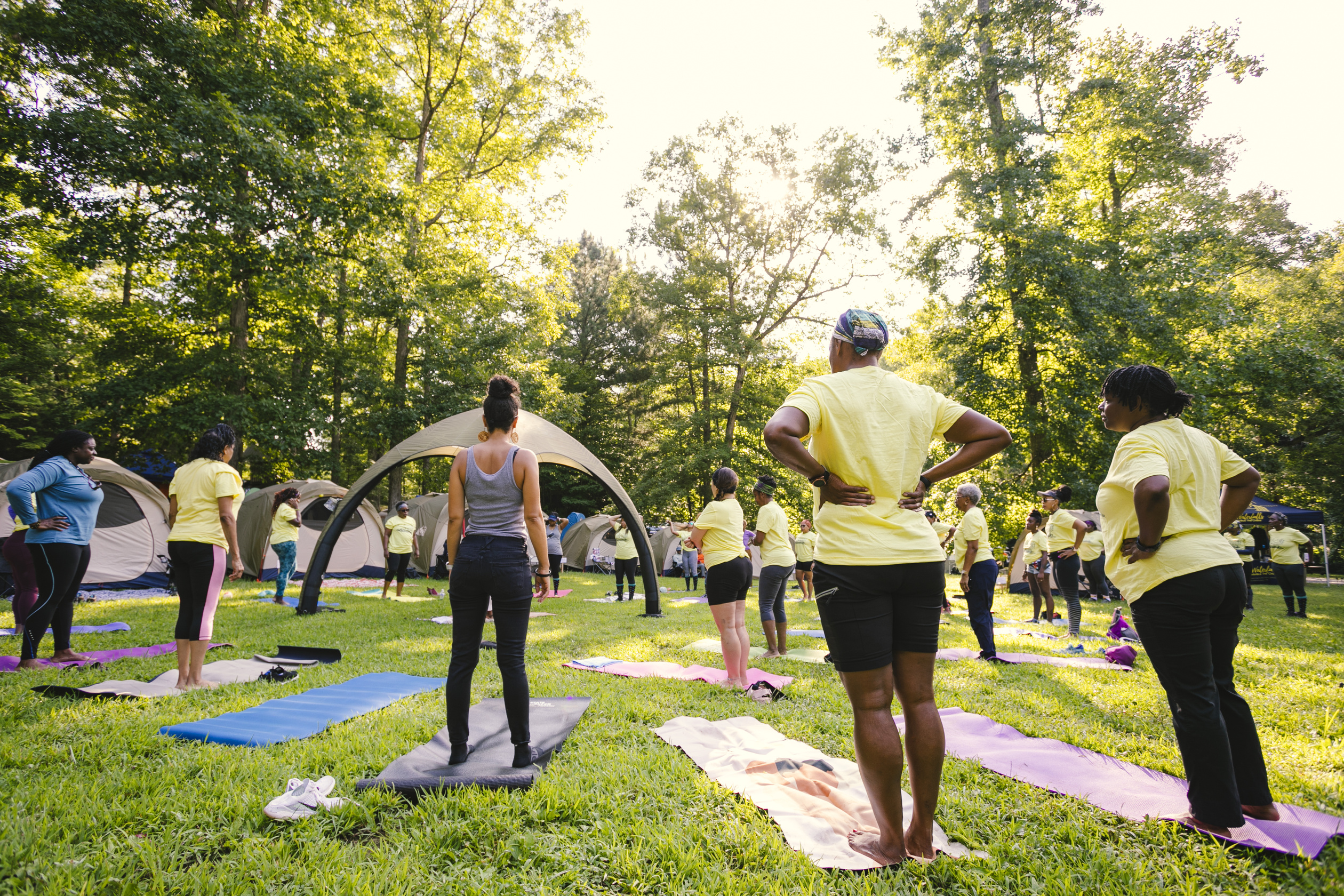 group of women doing yoga at a camping retreat